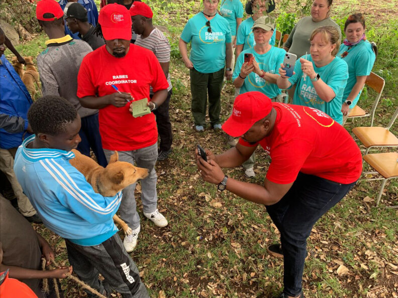 Boy holding dog that is having his picture taken for the facial recognition database.