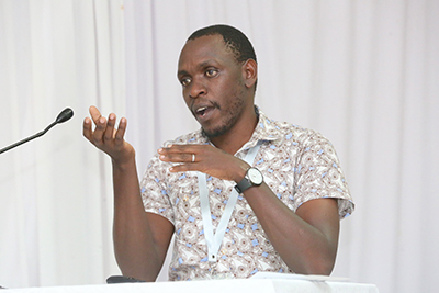 Dr. Ng'etich speaking at a conference. He is seated.