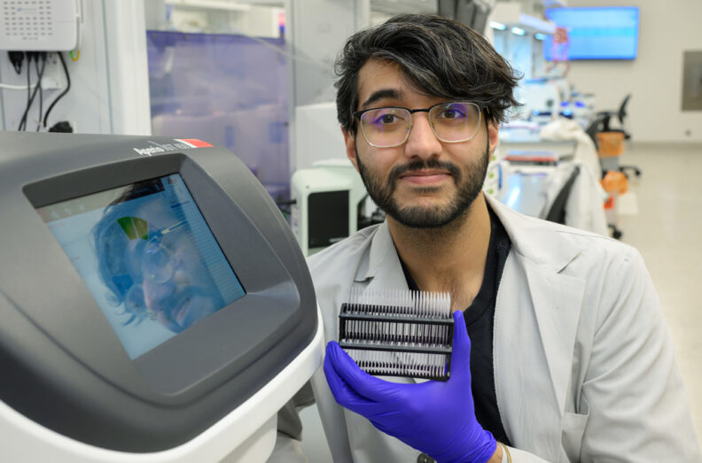 Jasson Makkar, a PhD graduate student poses next to an Aperio digital pathology slide scanner made by Leica located in the histopathology lab in WSU’s Washington Animal Disease Diagnostic Laboratory in Pullman.