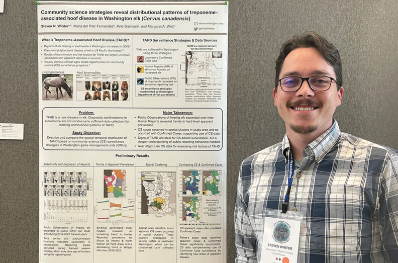 Close up image of Steve standing in front of his research poster.