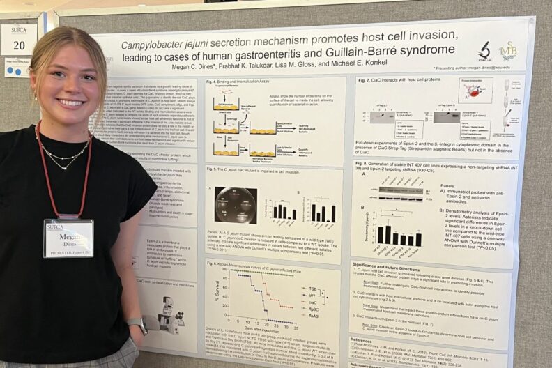 Megan Dines poses in front of her scientific poster.