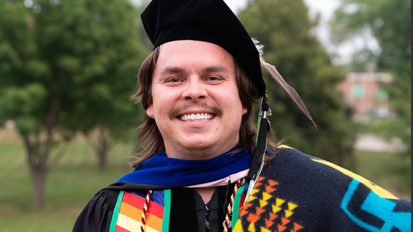 Cole in the graduation robe, cap and regalia.
