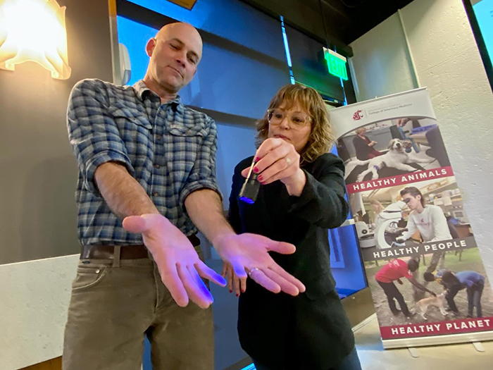 Dr. Craig McConnel as part of a demonstration of germs on hands.