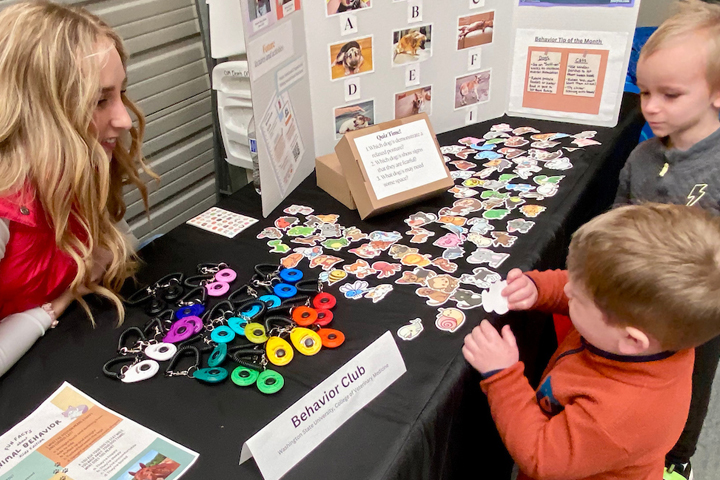 Two young boys deciding which sticker they want at the Behavior Club booth.