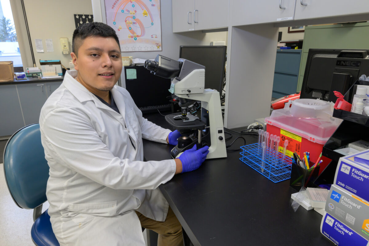Angel Delgado is shown at a microscope.