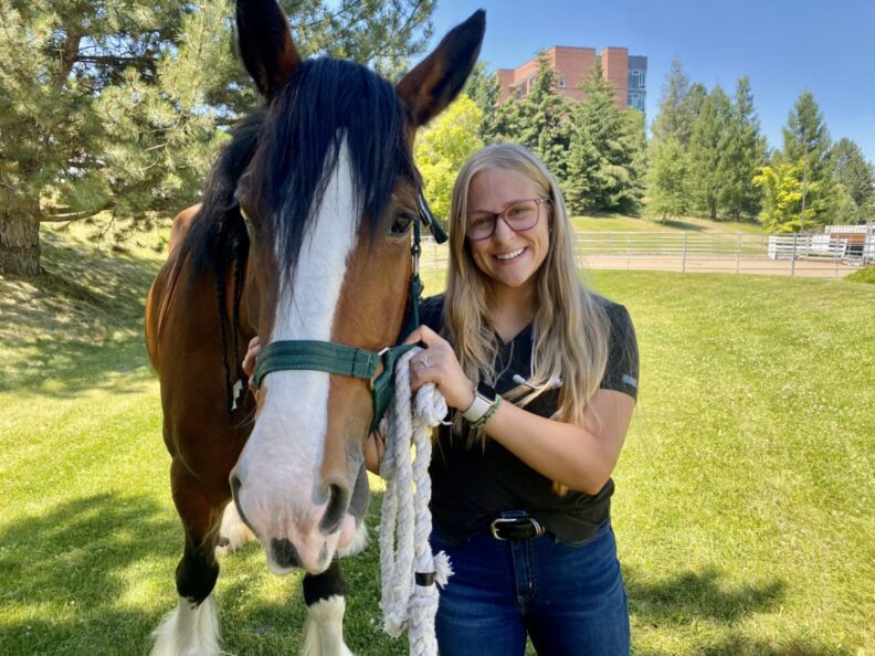 Emma Impala poses with a horse.