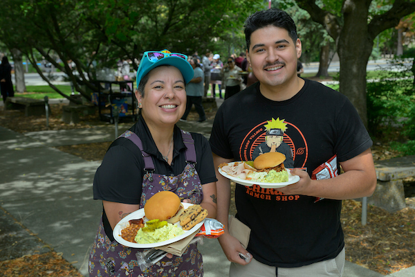 Two people with full plates and big smiles.