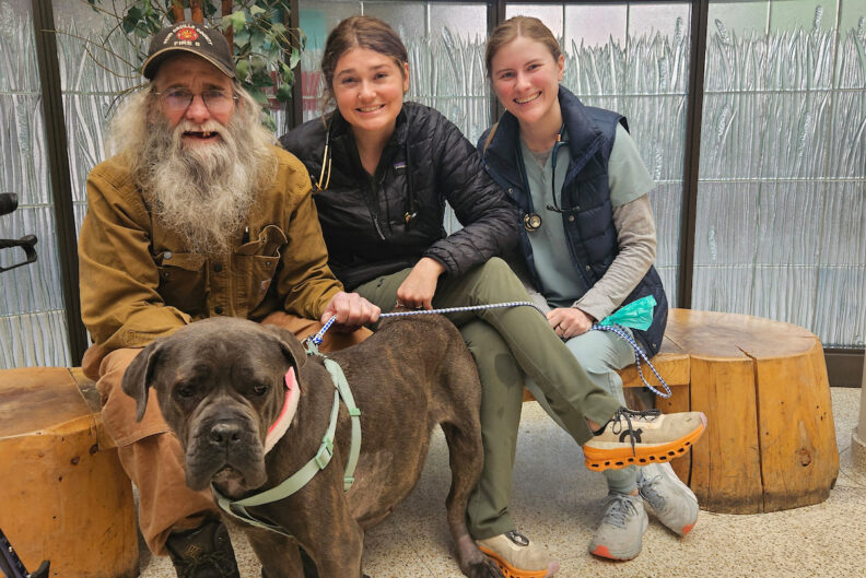 Dr. Anna Golden, center, poses for a photo with Sean Manwill, left, and his dog Gracie, a cane corso mastiff.
