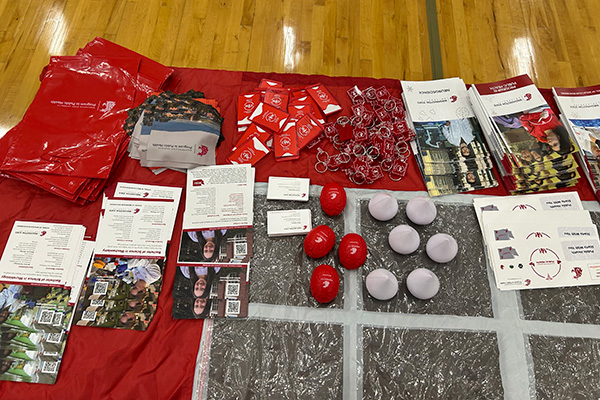 A photo looking down at a table with handouts, key chains and stress balls.