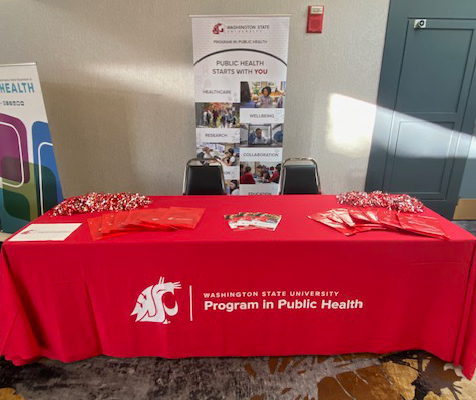 Photo of table set up with materials and a vertical banner to promote WSU's Public Health Program.
