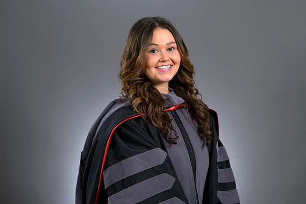 Caitlin wearing her graduation gown and DVM hood.