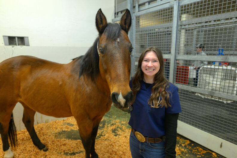 Hannah Thom poses with a horse.