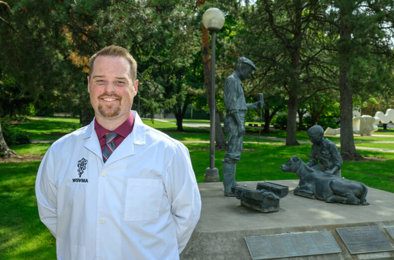 Terran wearing his white coat with the Caring Call statue in the background.