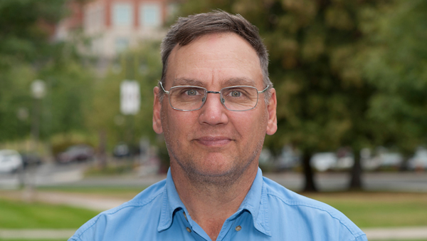 John outside of Bustad Hall on a sunny day.