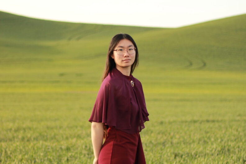 Melissa Yu stands in a green field.