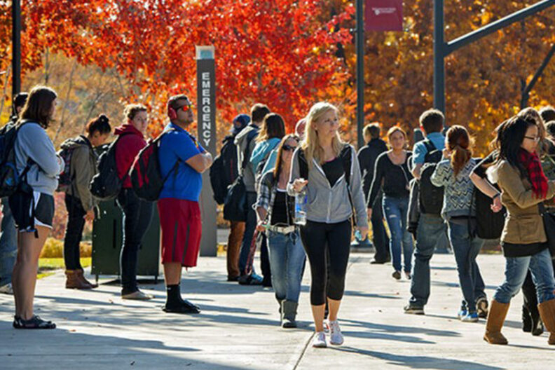 Students walking on campus in autumn.