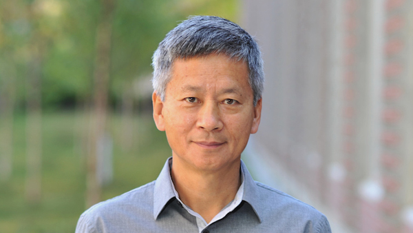 Chengtao outside. Wearing a light grey button up shirt.