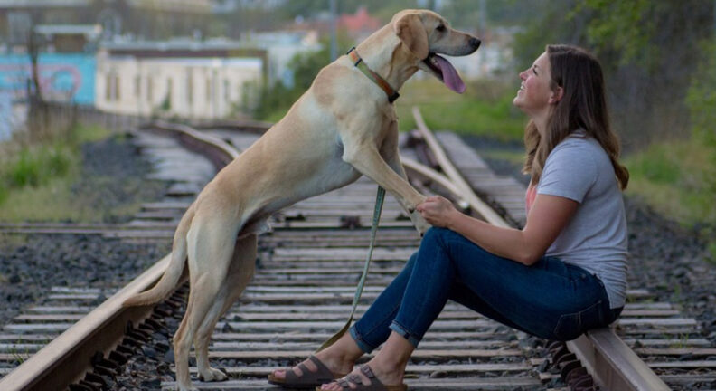 Samantha Sroczyk with her dog, Otter, on the railroad tracks in Pullman.