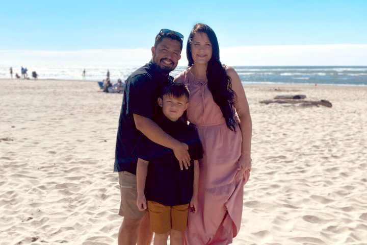 Lara with her family on a white sandy beach.
