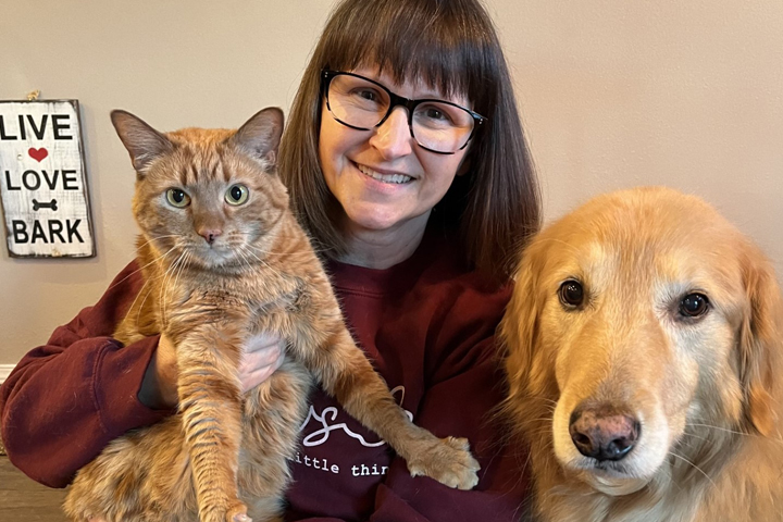 Connie with one of her cats, and her dog, Barkley.