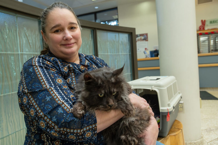 Kerri Kuykendall holds Woodford, a two-year-old Maine coon cat, in the lobby of the Veterinary Teaching Hospital.