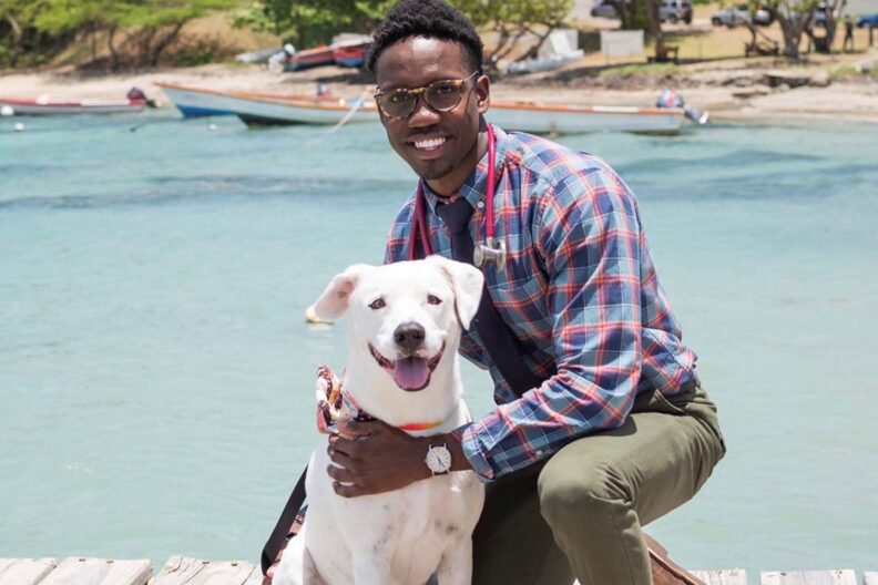 Clifford Petit with a dog on a dock.