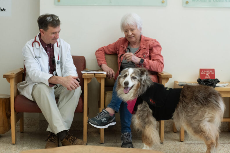 Rubie, an Australian shepherd, sits with her owner, Lynnea Thibodaux, right, as they talk with Dr. Rance Sellon, a professor and oncology veterinarian at WSU’s Veterinary Teaching Hospital.