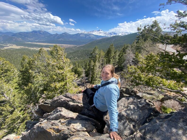 Kristie McGourin sits on a pile of rocks during a hike in the mountains.