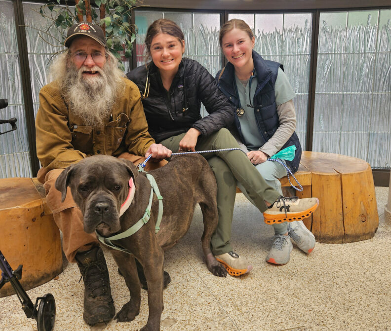 Cardiology resident Dr. Anna Golden, center, poses for a photo with Sean Manwill, left, and his dog Gracie, a cane corso mastiff.