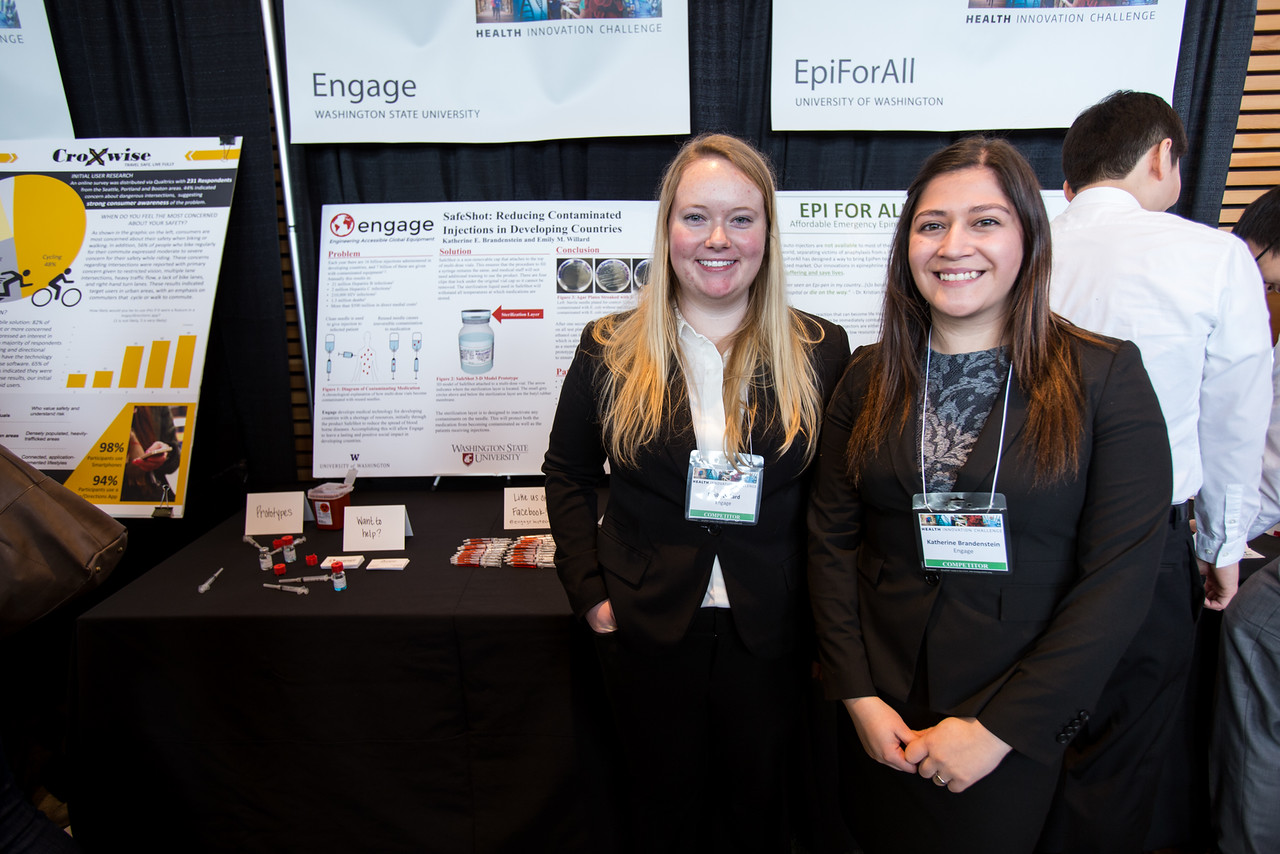 Students stand in front of displays describing their idea.