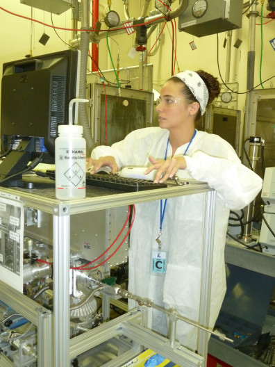 Courtney Herring typing on a keyboard while wearing PPE in a lab.
