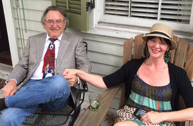 Brion and Ronda hold hands while sitting on a porch.