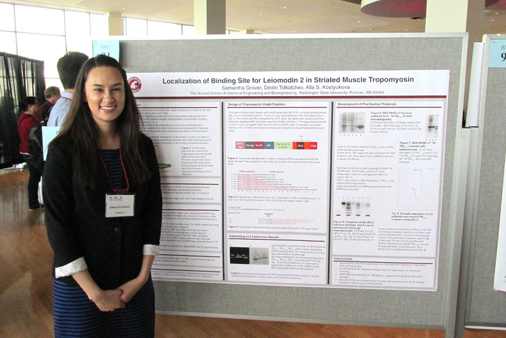 Samantha Grover standing next to a poster about her research.