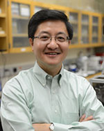 Yong Wang posing with arms crossed.