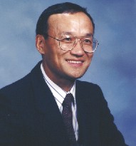 James Lee in a suit and tie, wearing glasses.