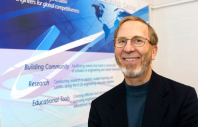 Denny Davis wearing a black coat and smiling.