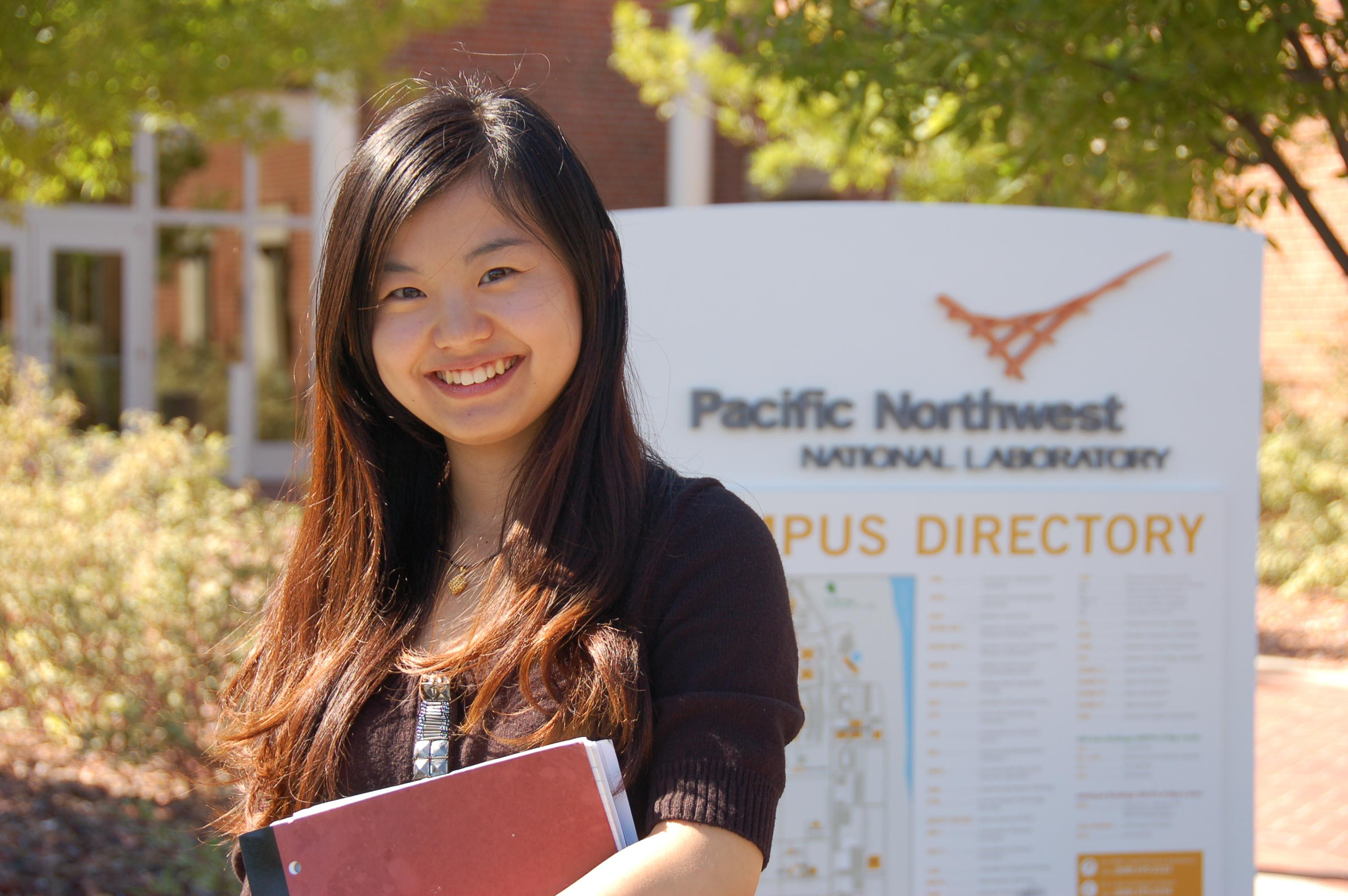 Xiaohui (Sophie) Ju outside by a campus directory for the Pacific Northwest National Laboratory.