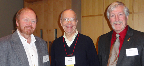 Three people wearing name tags and smiling at the camera.