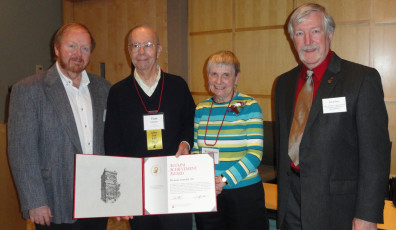 Four people posing with an award.