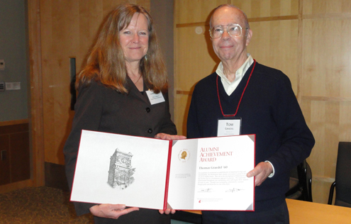 Two people posing with an award.