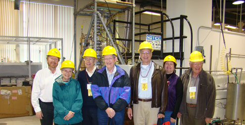 Group of people wearing yellow hard hats.