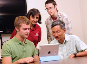 Four people looking at tablet PC.