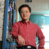Yong Wang standing near scientific equipment.