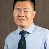 Hongfei Lin wearing glasses and a tie.