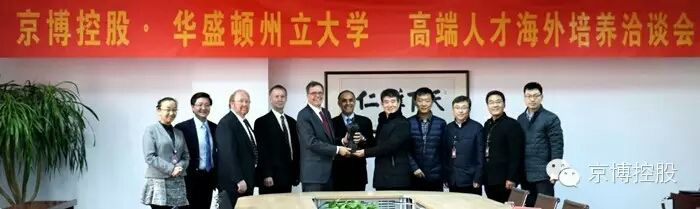 Eleven executives posing in a row under a banner with Chinese writing.