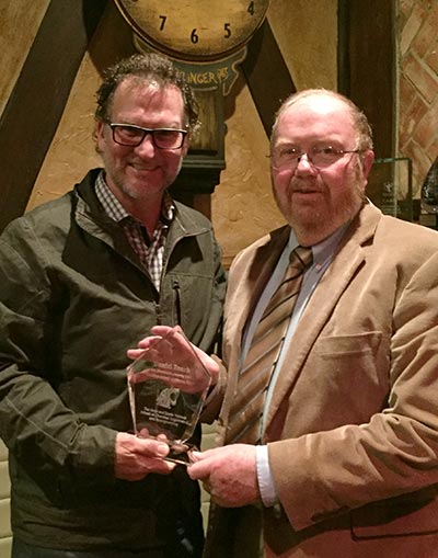 Dan Roark receiving an award from Jim Petersen.