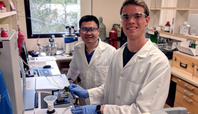 Kristian Gubsch and Dr. Hongfei Lin wear PPE while working in the lab.