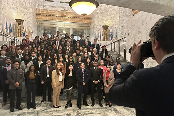 Roughly 75 students standing on the marble steps inside of the Legislative Building in Olympia.