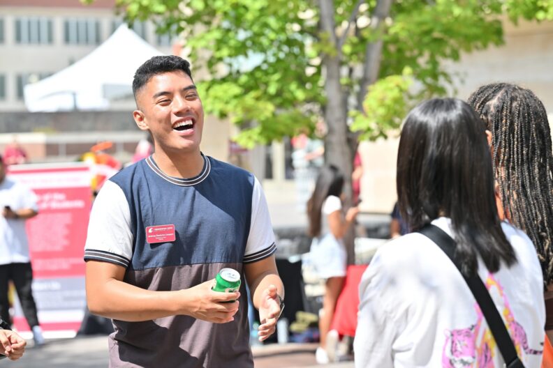 Three students talking at the WOW resource fair