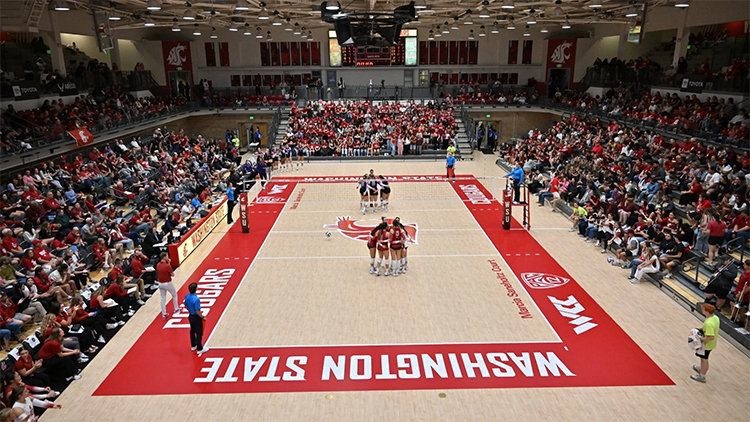 Overhead photo of the women's volleyball team huddled up during a game in Bohler Gym.